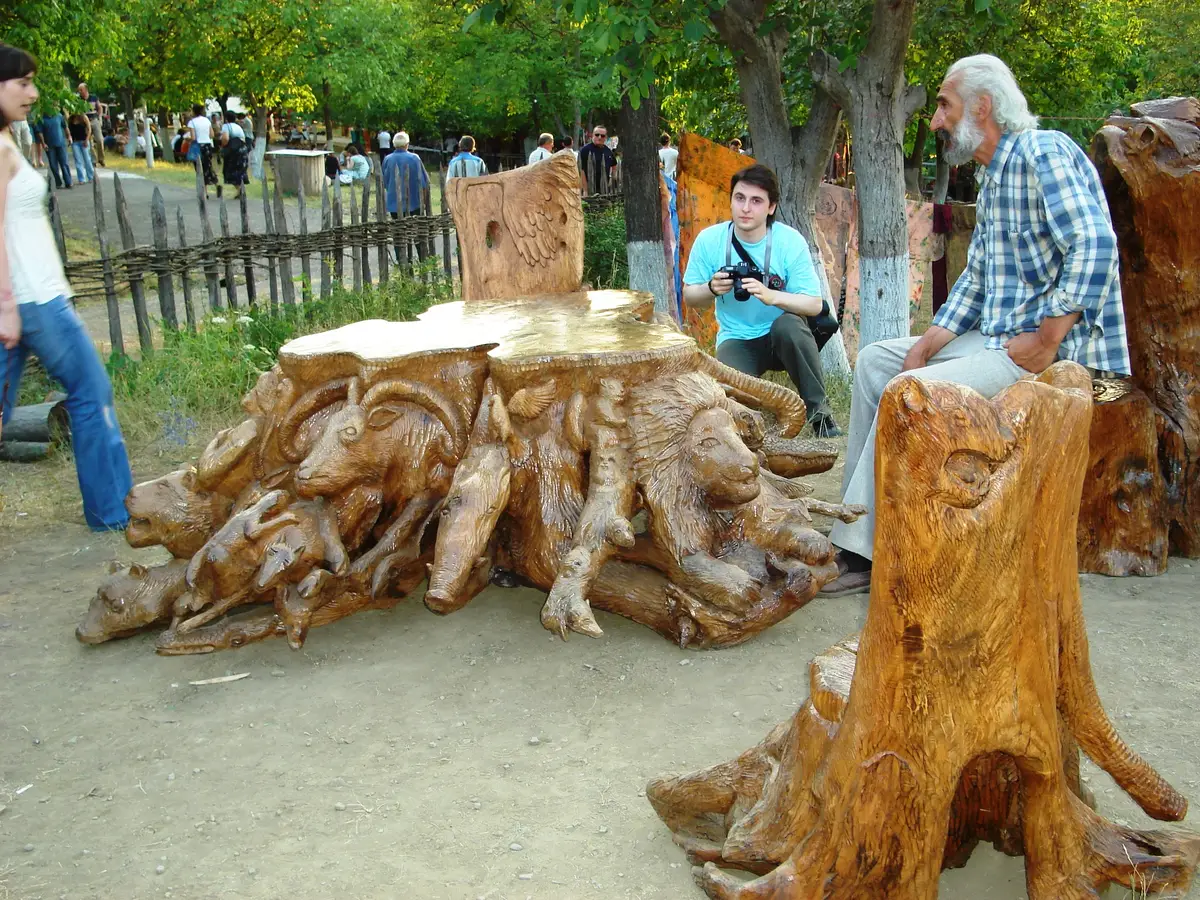 Carved tree stumps shaped into animal figures and a low table on the festival ground