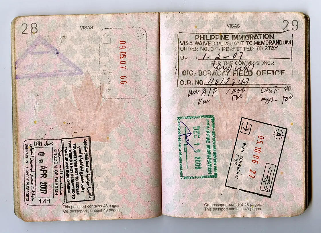 An open passport spread covered in immigration entry and exit stamps