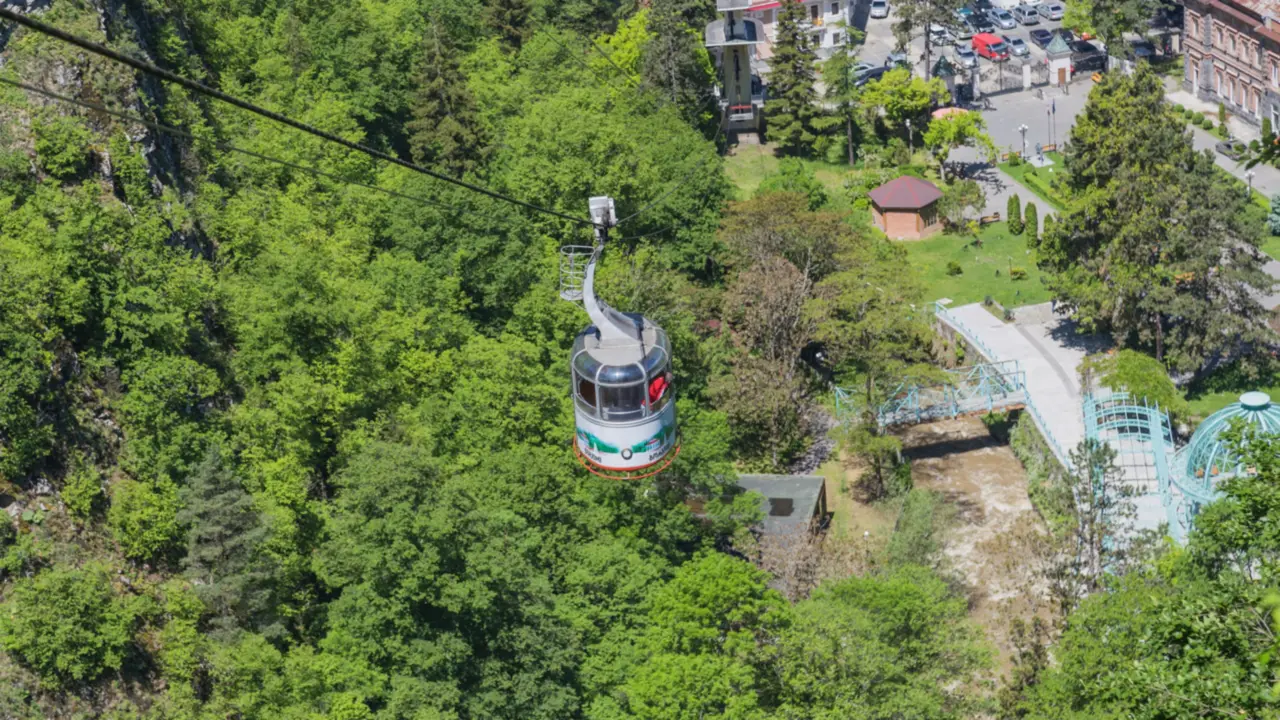 A Borjomi cable car cabin over the wooded gorge, with the mineral water park below