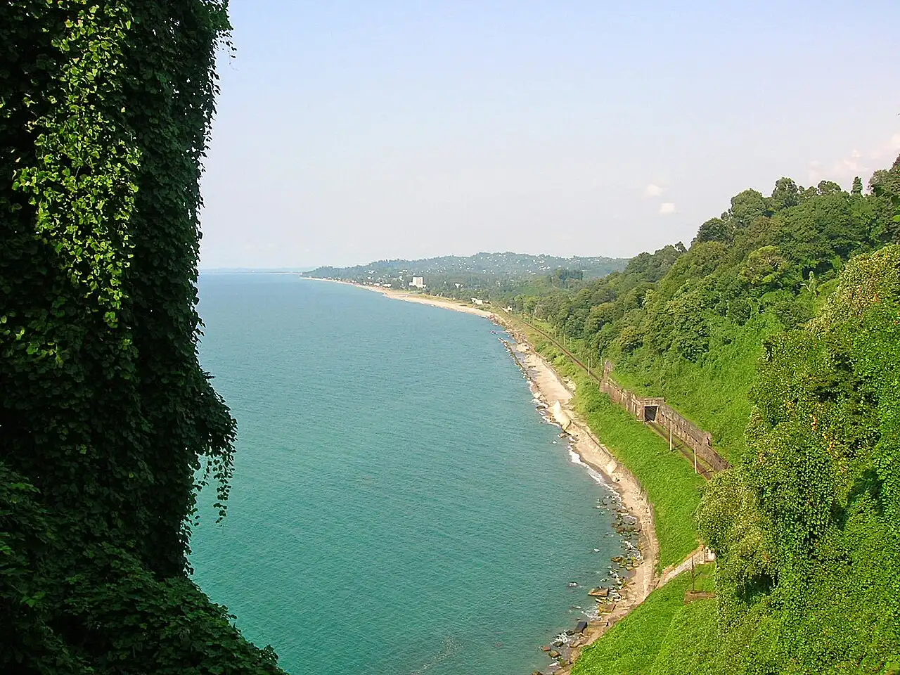 Turquoise Black Sea and a beach below the cliffs of the botanical garden