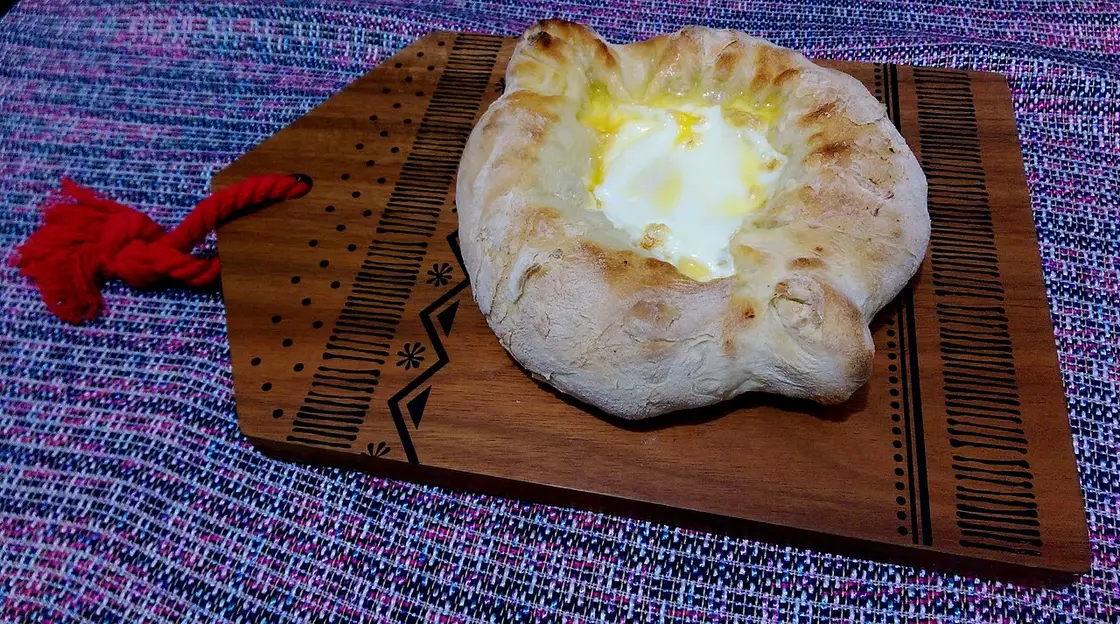 Adjarian khachapuri on a wooden board