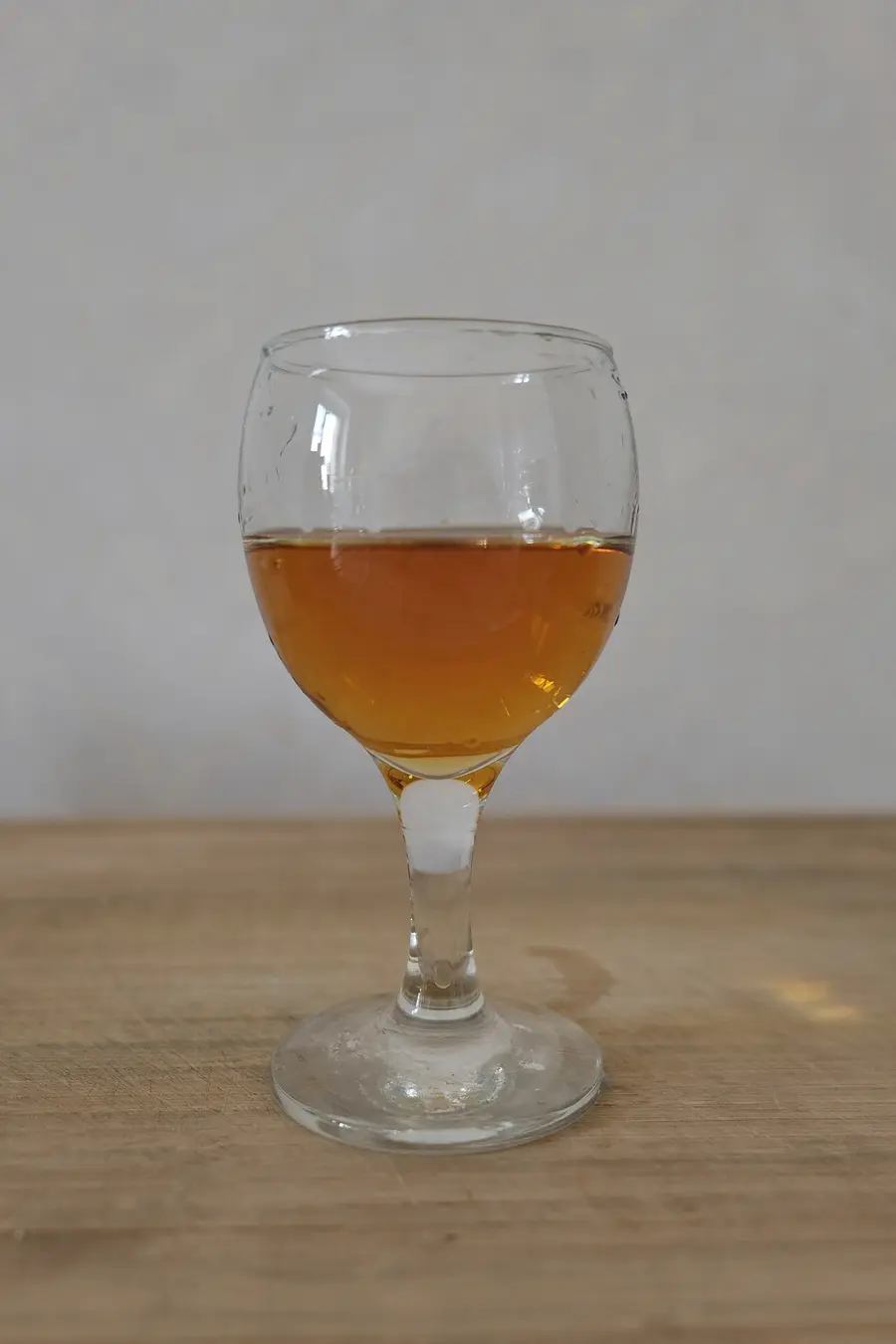 A glass of Georgian qvevri wine next to a clay jug