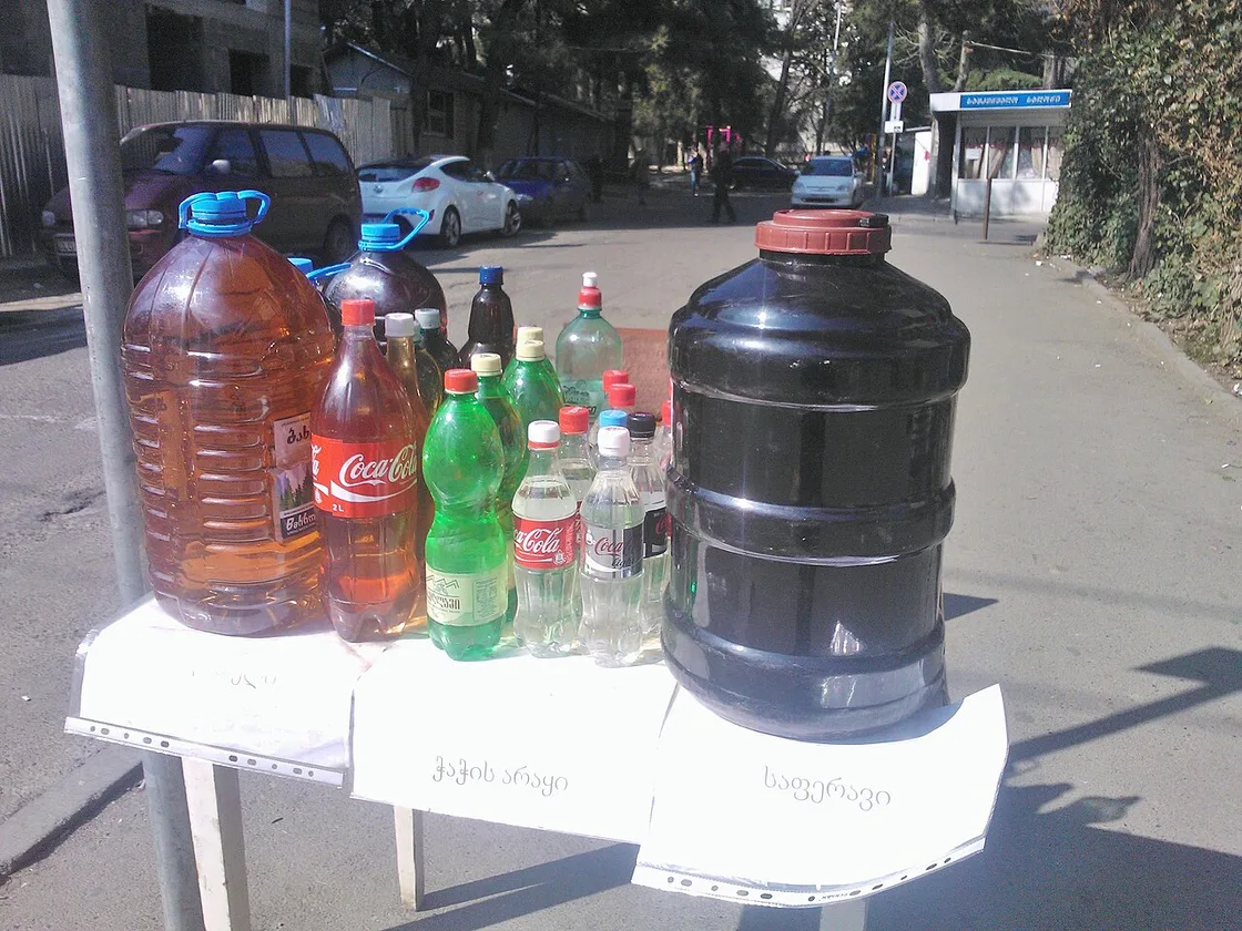 A street stall in Tbilisi selling homemade wine and chacha in plastic bottles