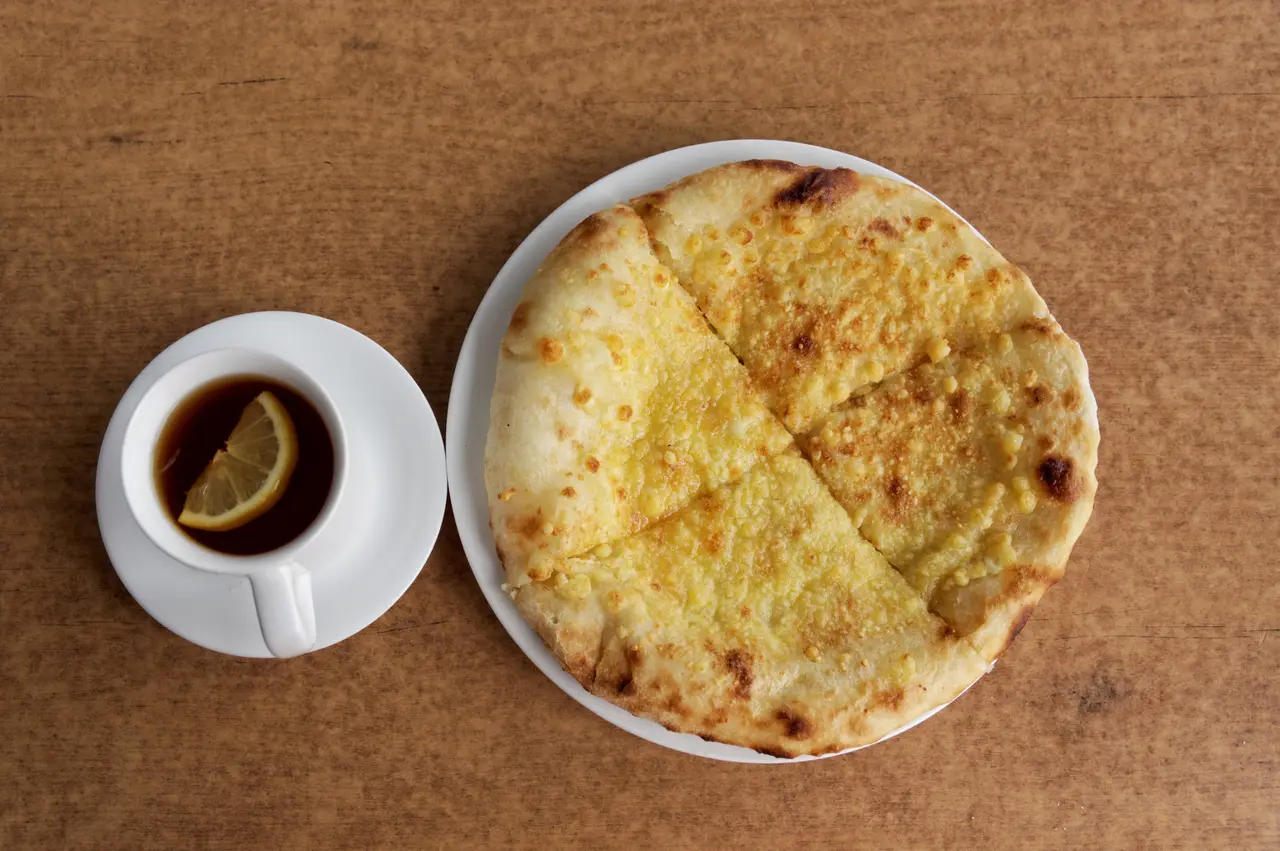 A round Imeretian-style khachapuri cheese bread on a plate