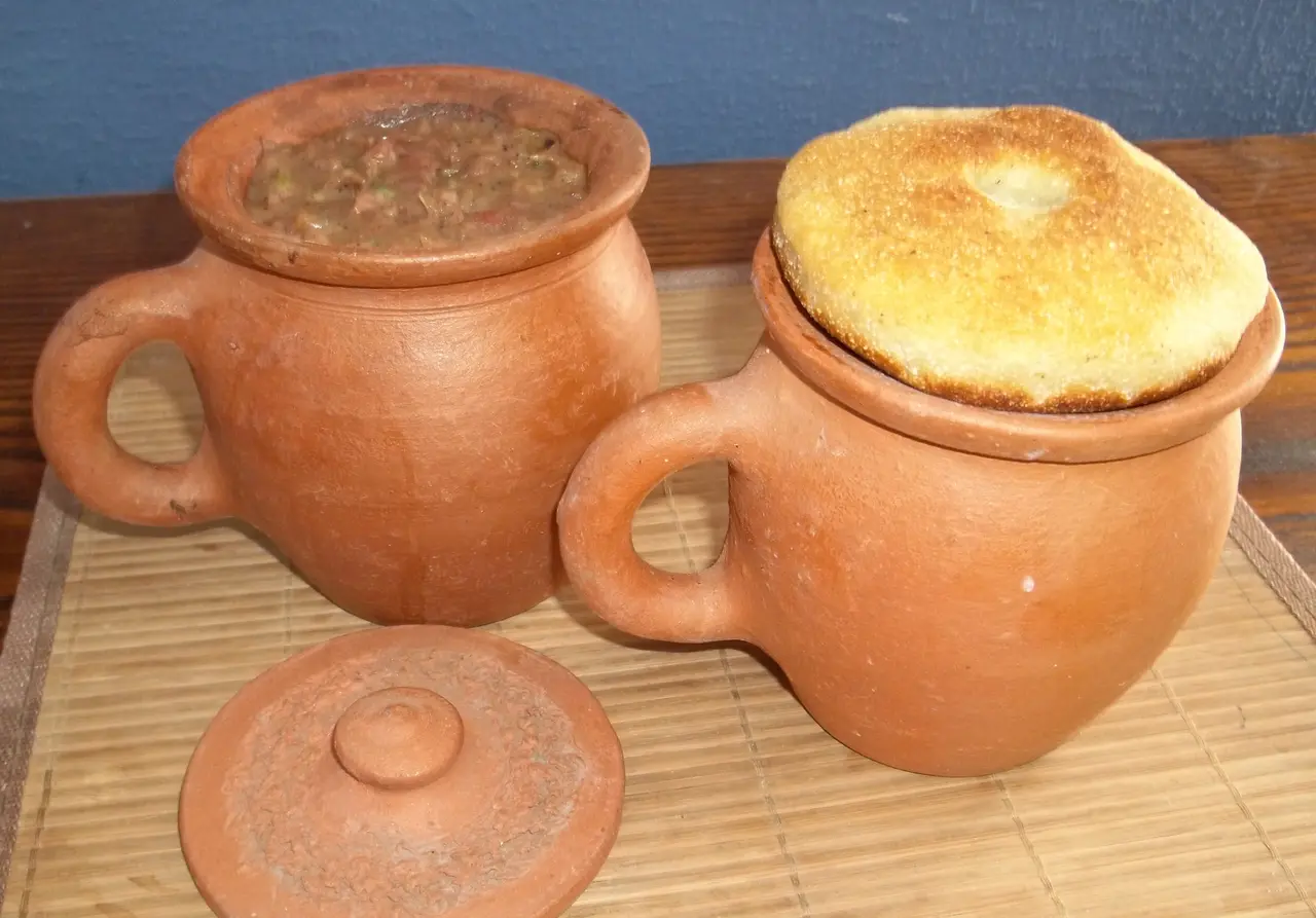 Lobio stewed beans in clay ketsi pots topped with mchadi cornbread
