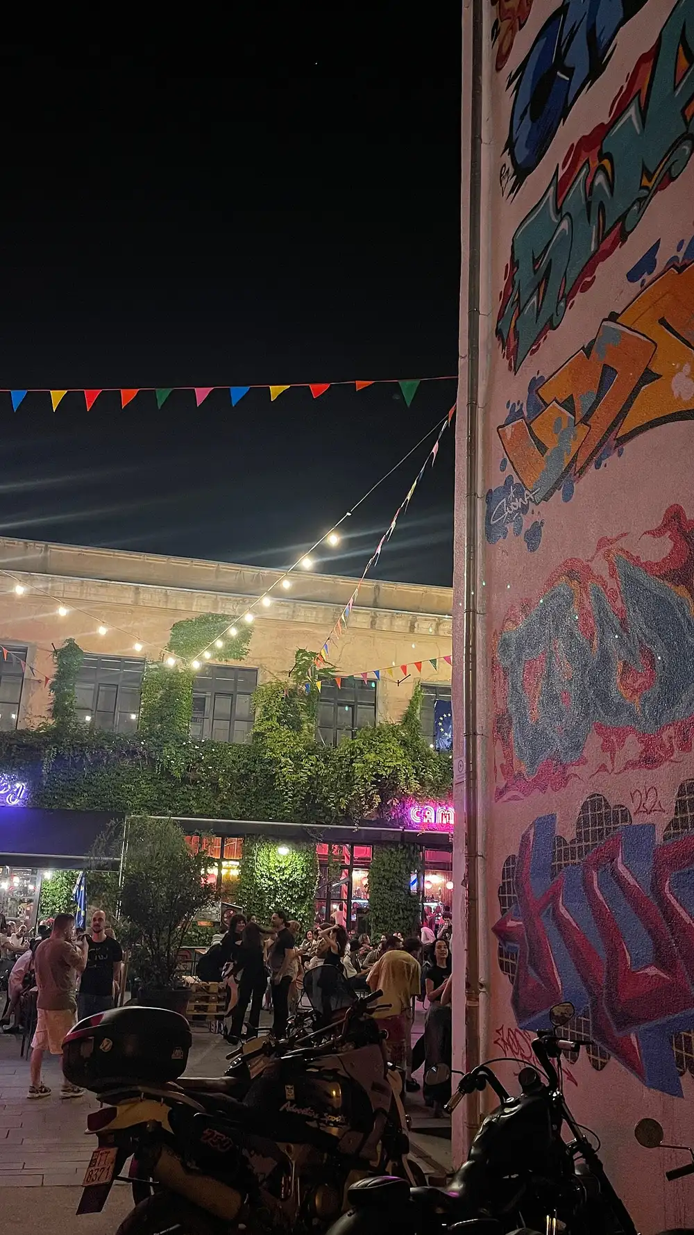 The Fabrika courtyard in Tbilisi at night: string lights, bunting and a graffiti-covered wall