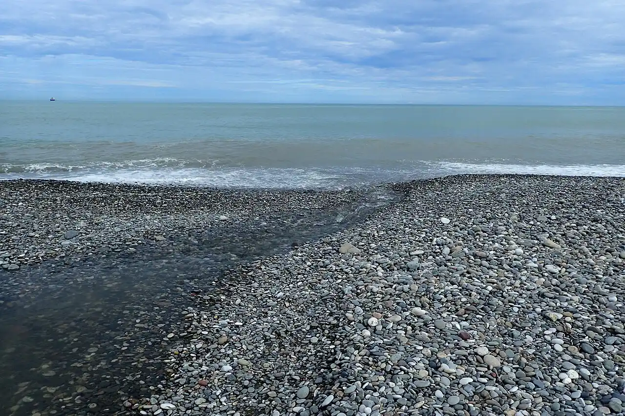Pebble beach at Makhinjauri with waves and an overcast sky