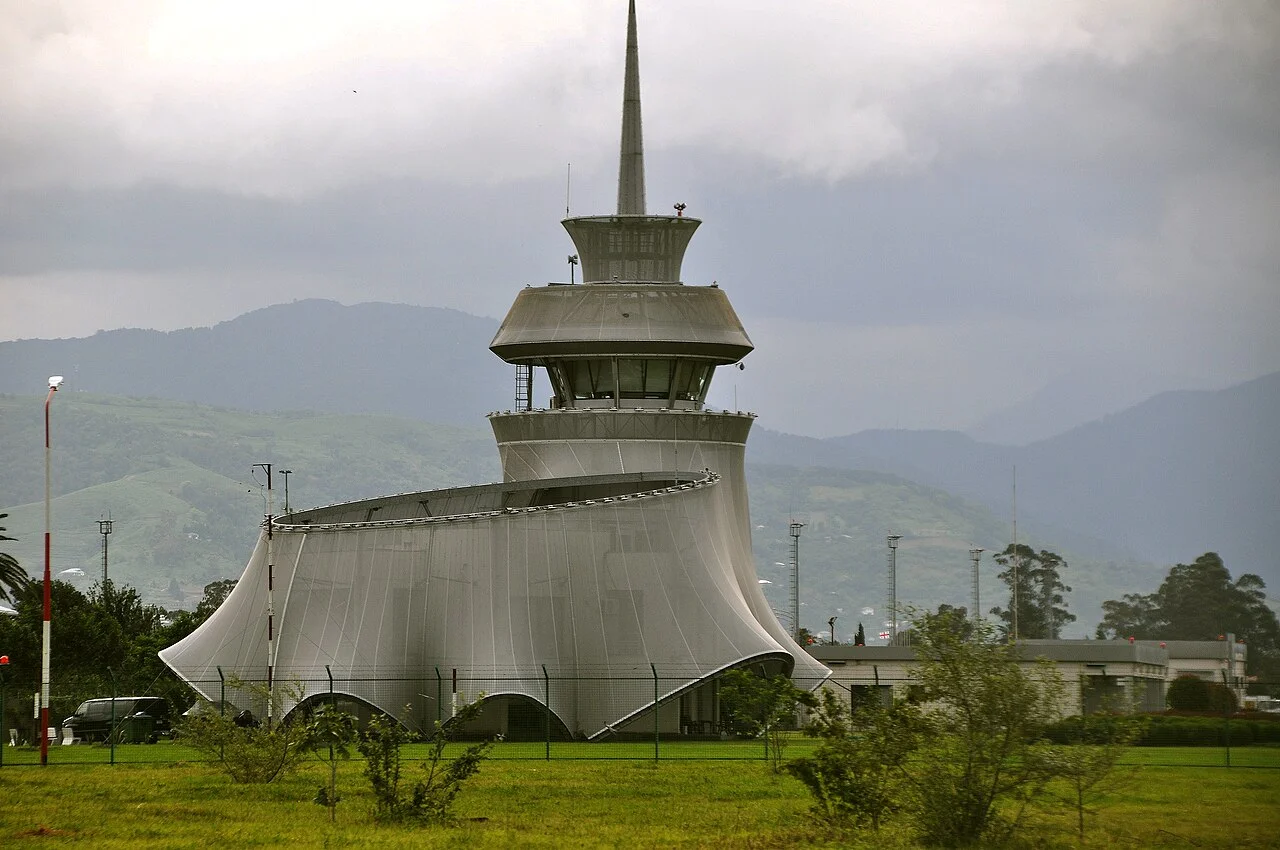 Distinctive wing-shaped control tower of Batumi airport against green hills