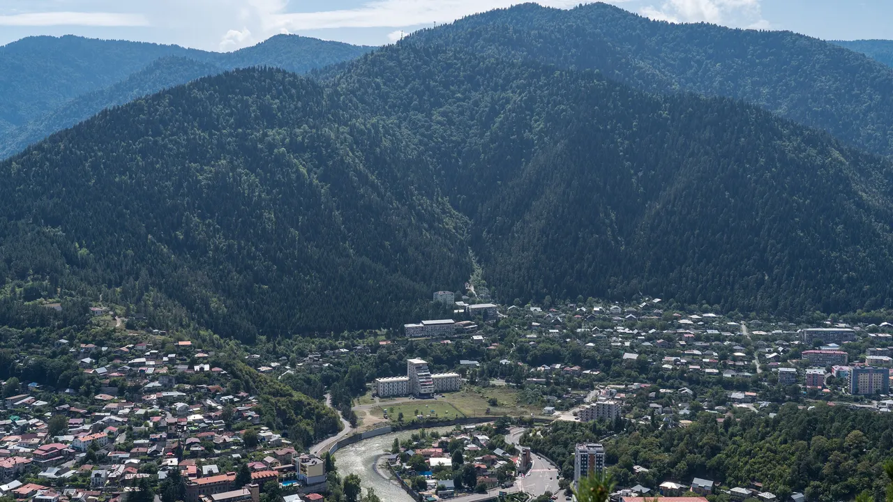Borjomi spread along the river below forested mountains, seen from the Cross Mountain