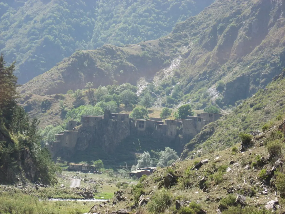 The slate towers of Shatili standing as a continuous wall above the river