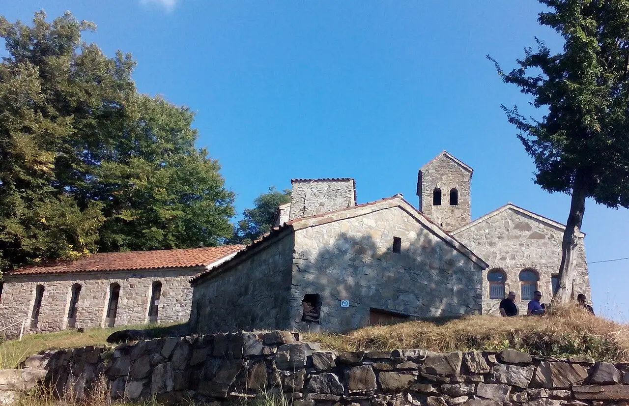 Stone churches of Nekresi Monastery with tiled roofs on a green slope