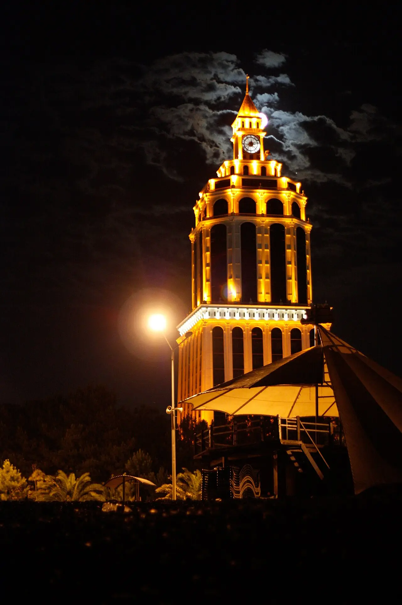The lit-up tower of the Sheraton Batumi hotel at night