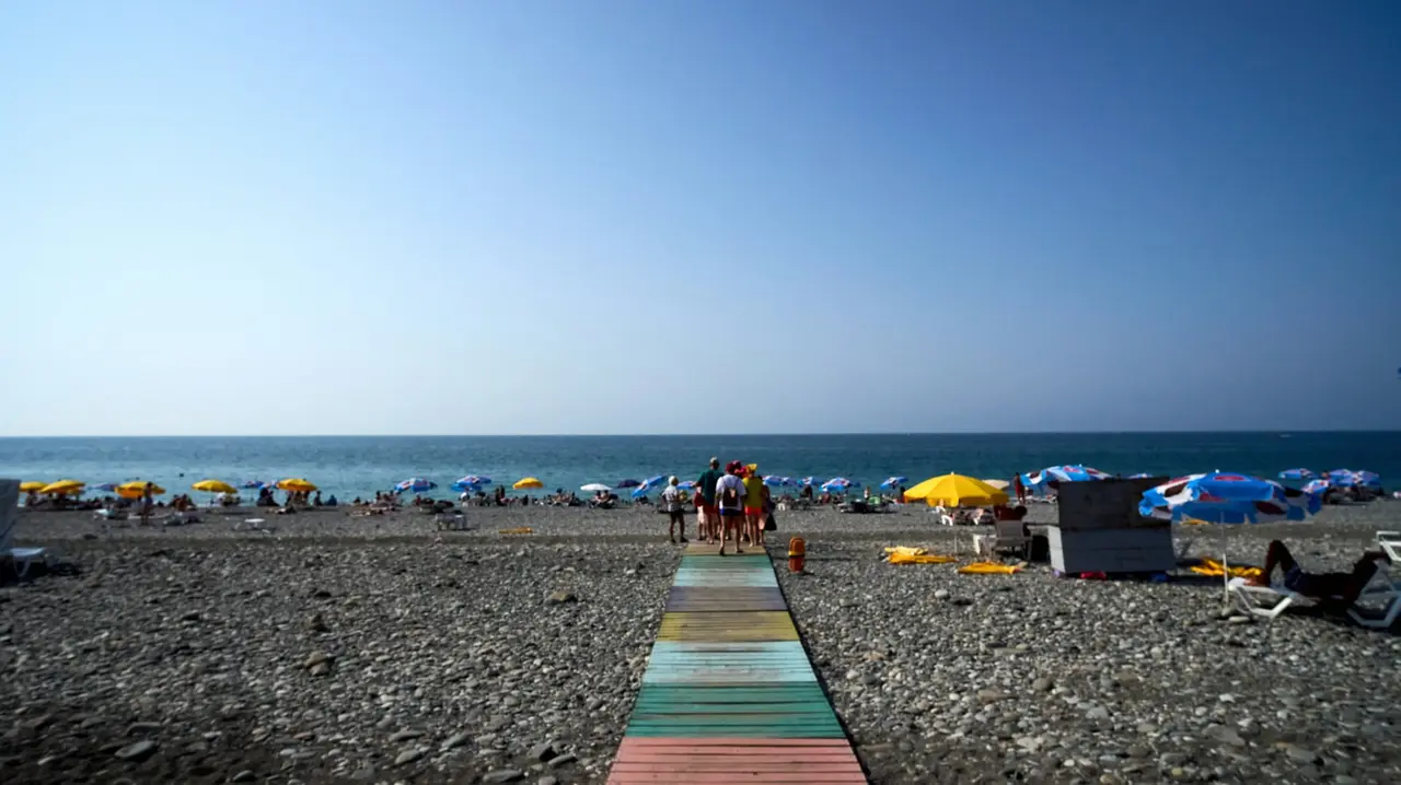 A Black Sea beach with umbrellas and swimmers in summer