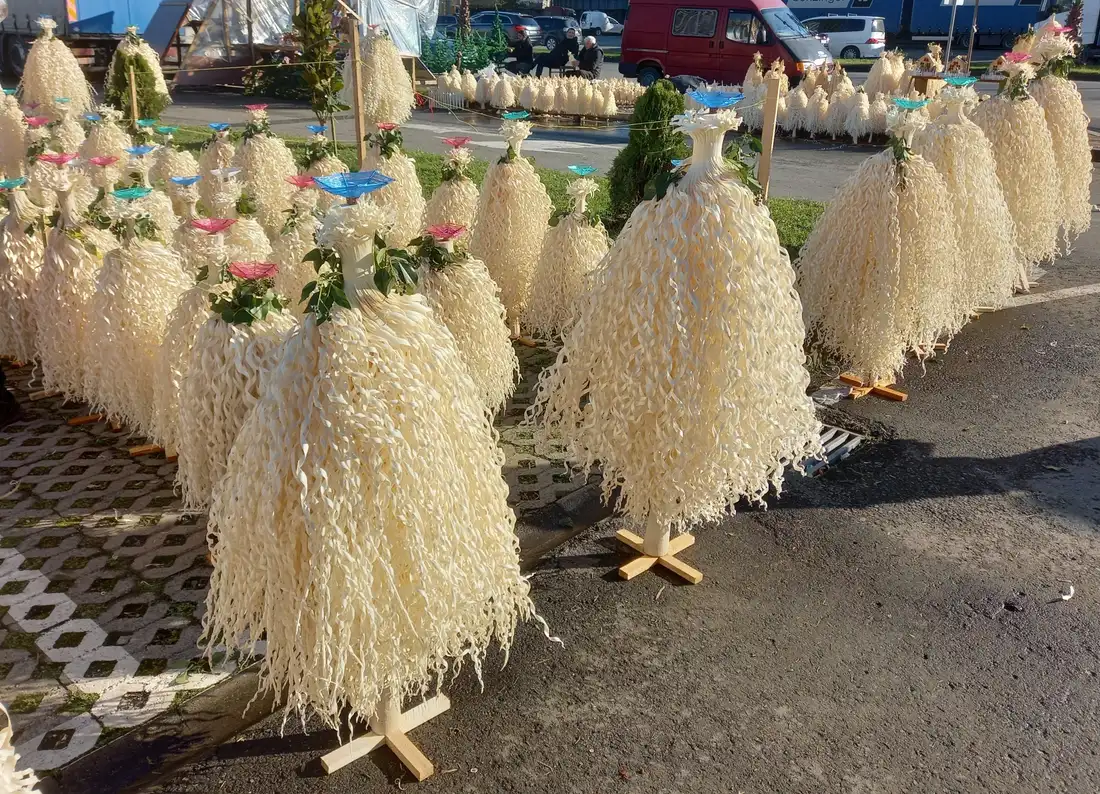 Rows of white chichilaki, traditional Georgian New Year trees of shaved hazelnut wood, for sale at an outdoor market
