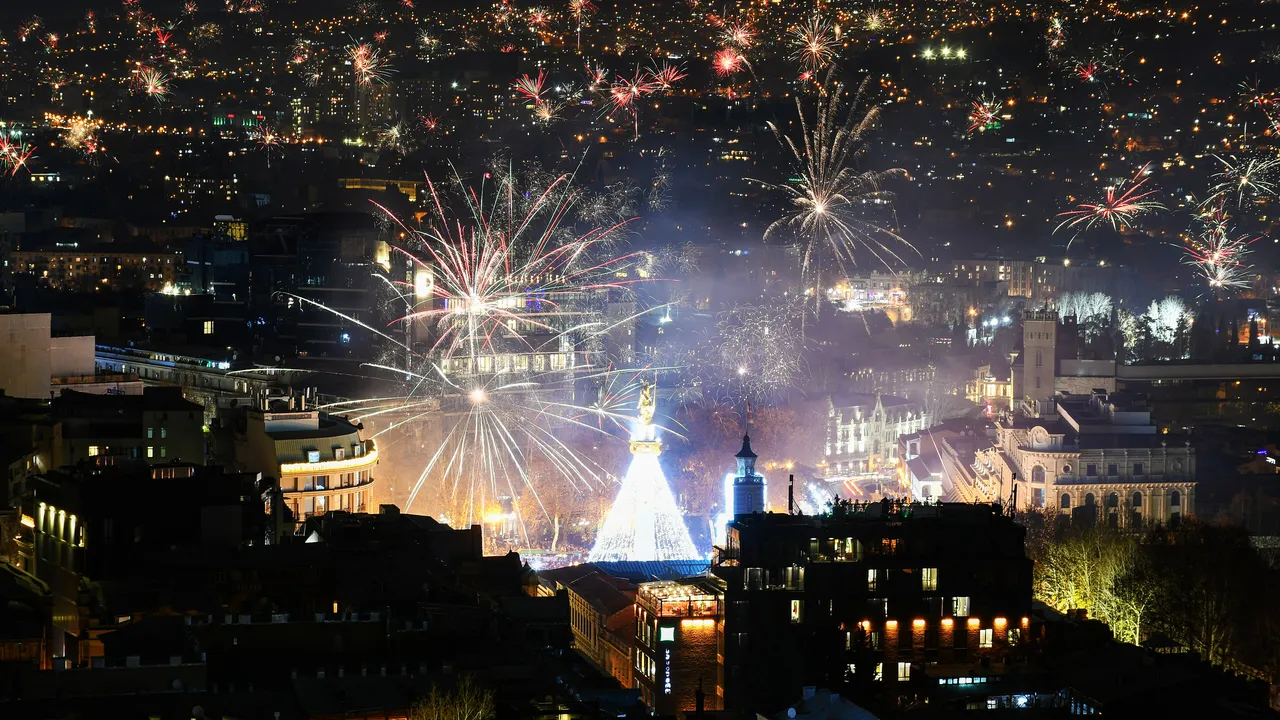 Fireworks bursting over central Tbilisi on New Year night, with the lit-up monument on Freedom Square in the middle