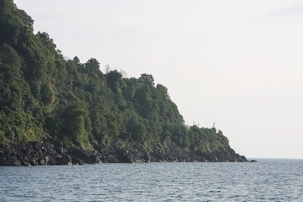 Rocky green headland and clear sea at Kvariati