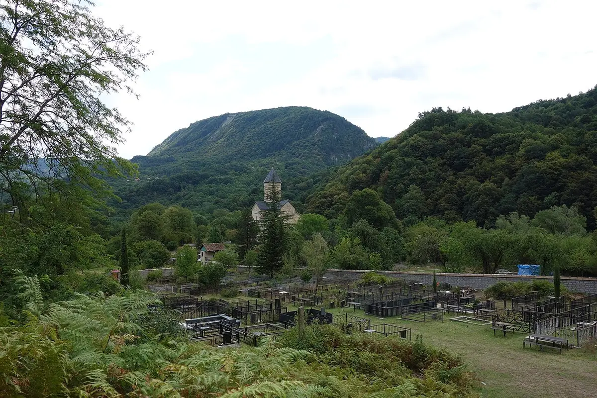 Barakoni church with its conical dome against wooded mountains