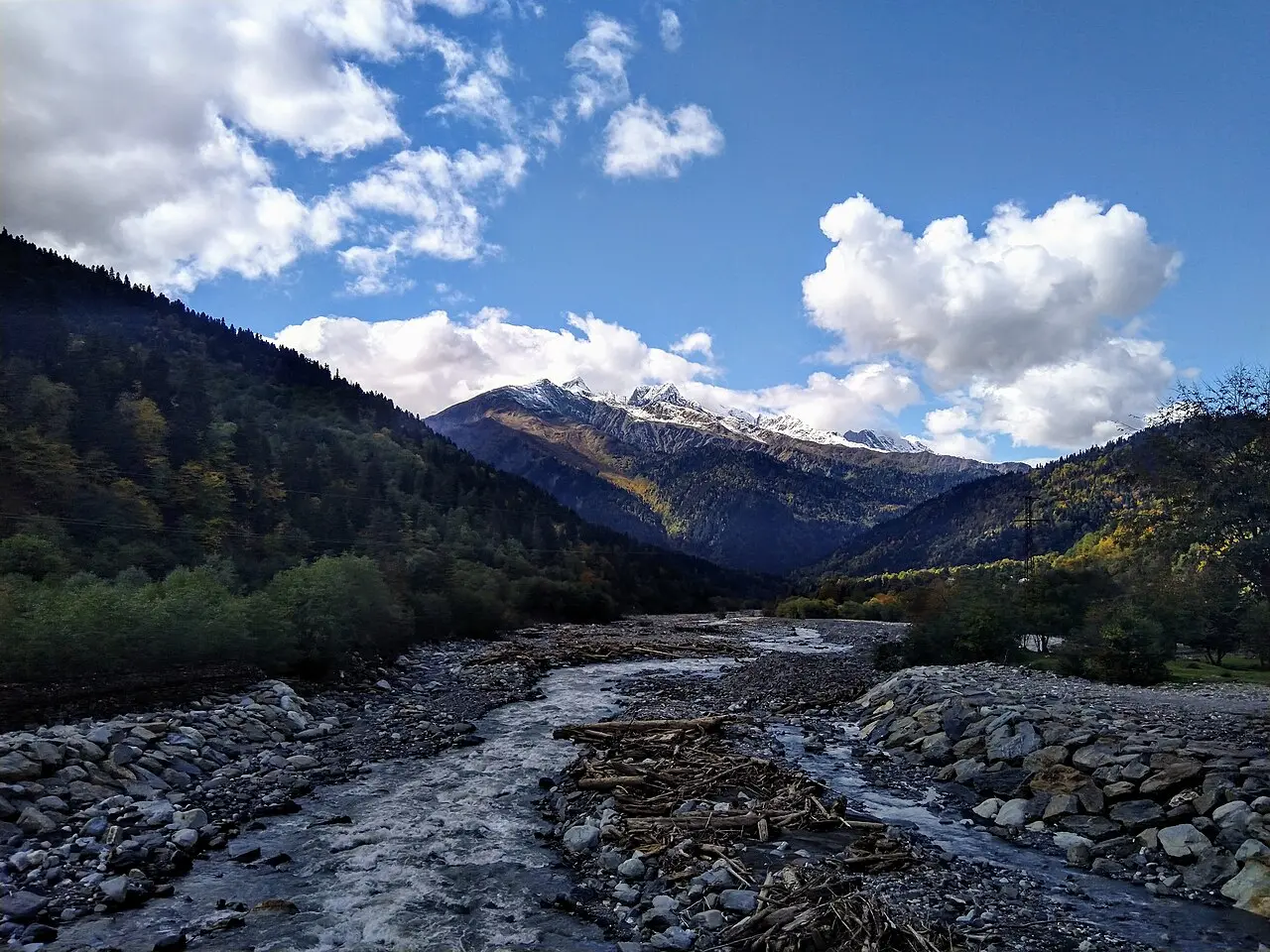 The Chanchakhi River in mountain Racha: a gravel bed, forest and snow-capped peaks