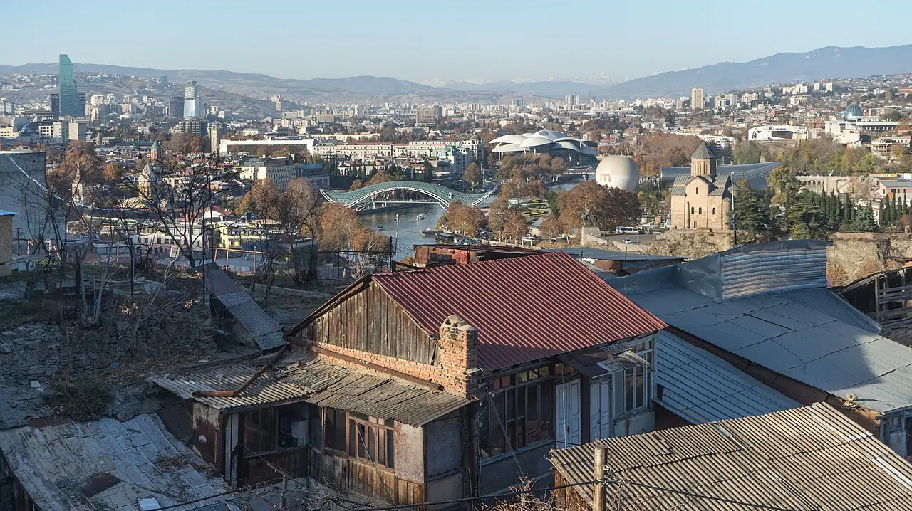 Panorama of Tbilisi with the Bridge of Peace, old town and mountains behind