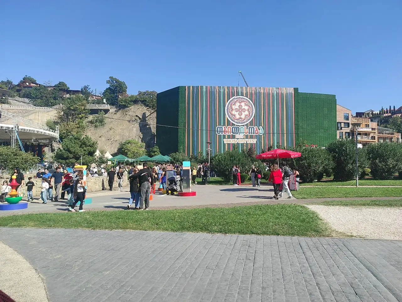 Wall branded Tbilisoba 2024 and Tbilisi City Fest in Rike Park with people on the square in front