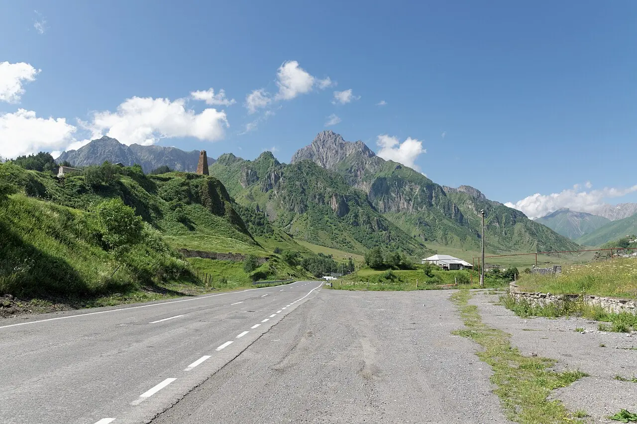 The Georgian Military Road winding through mountains near Sioni, with dramatic clouds overhead