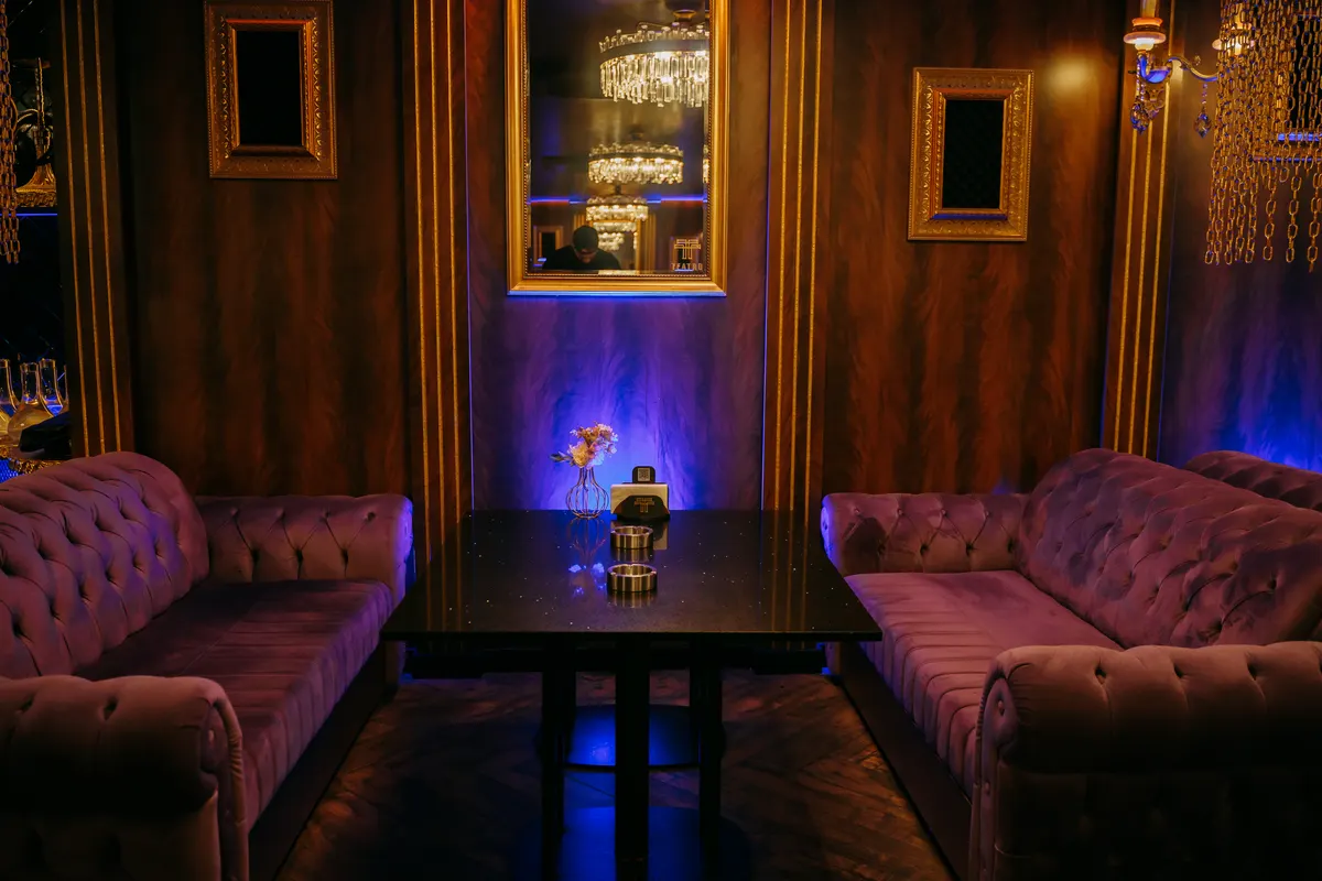 A Teatro VIP area with a chandelier, mirrors and velvet sofas