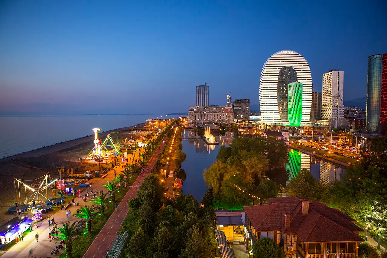 The Batumi waterfront at dusk with a ferris wheel and the Courtyard tower