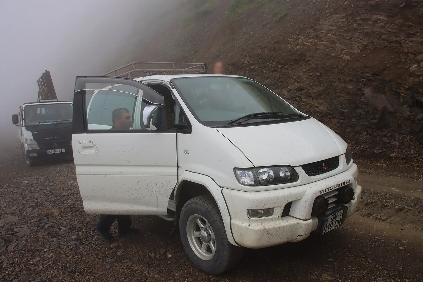 A 4x4 on the dirt road of the Abano Pass in fog