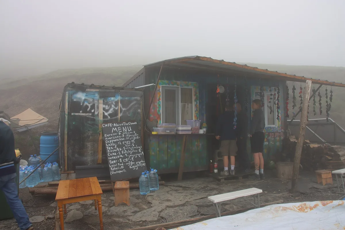 The Above the Clouds cafe on the Abano Pass in fog, menu on a board