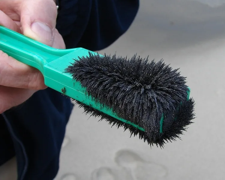 A magnet coated with black magnetic sand, the iron grains standing up like a brush