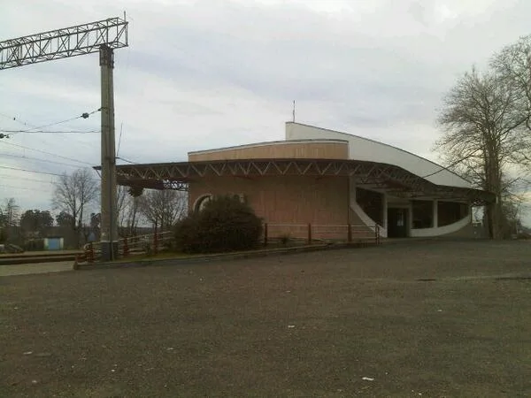 The Ureki railway station building with a canopy and overhead-line masts