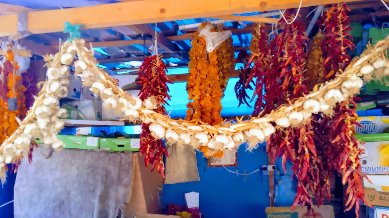 A spice market in Tbilisi: strings of garlic and red peppers