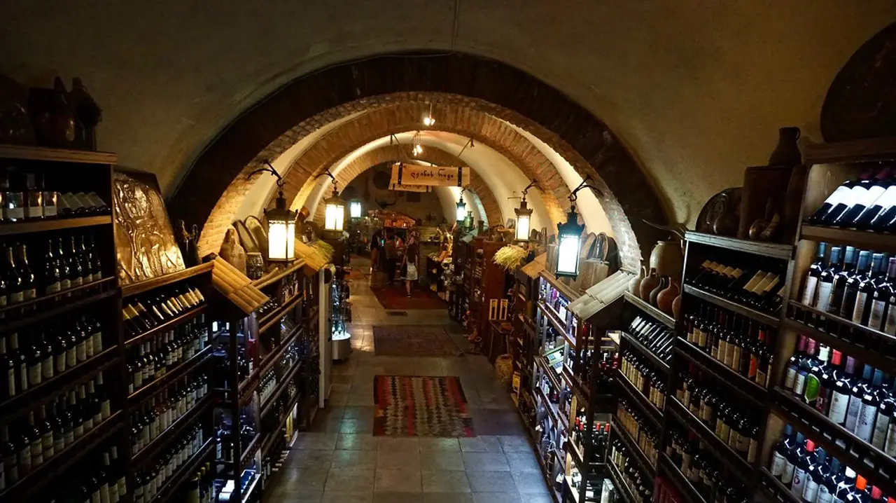 Interior of an underground wine bar with brick arches and shelves of Georgian wine in Tbilisi
