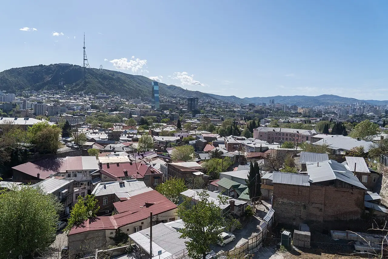 A panorama of Tbilisi rooftops with the TV tower and hills on the horizon