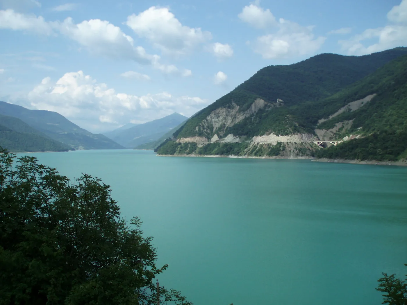 The turquoise Zhinvali Reservoir between wooded slopes